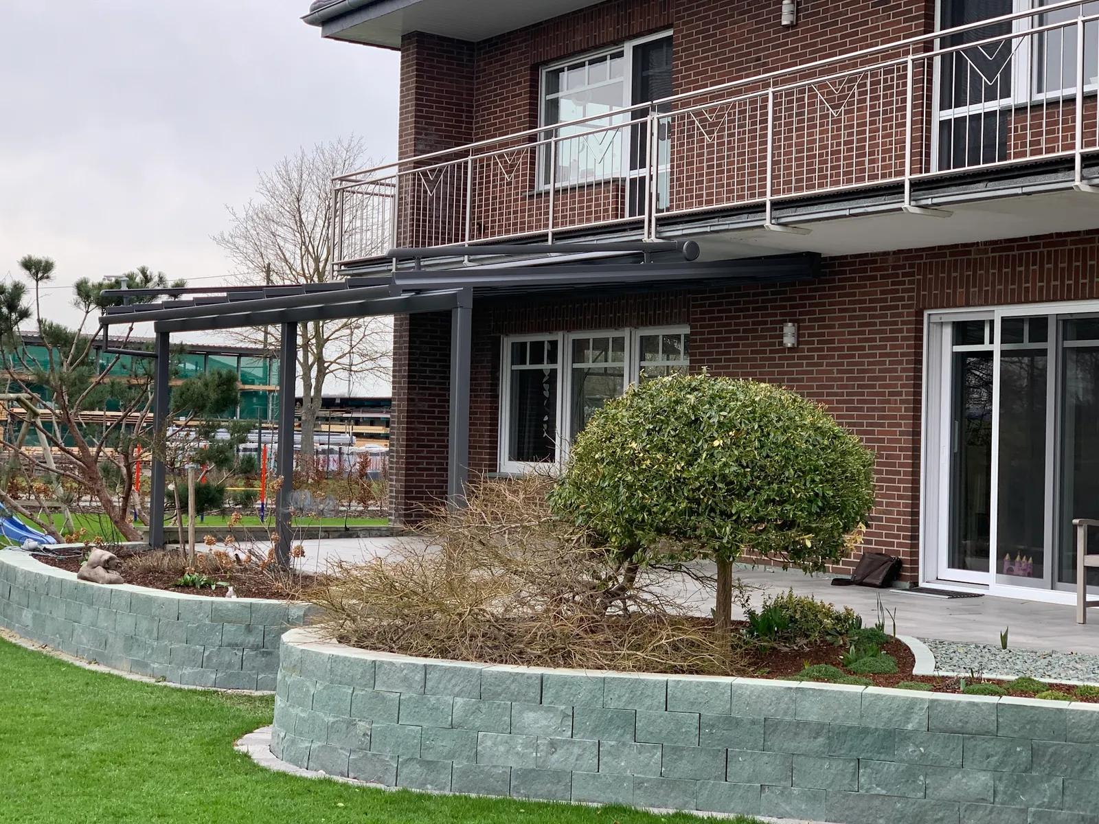 Gesamtansicht eines Klinkerhauses mit neuer Terrassenüberdachung