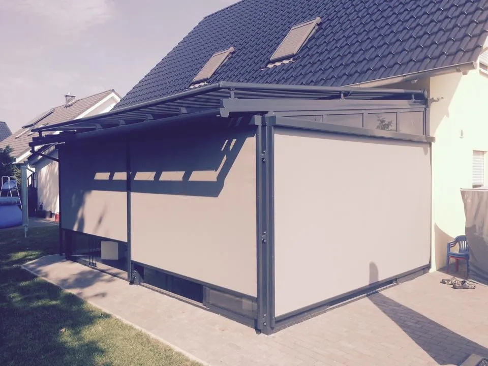 Anthrazitfarbenes Terrassendach mit textilen Sichtschutz-Rollos
