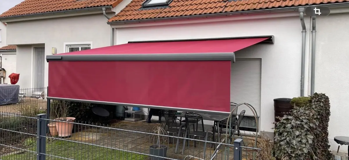 Rote Markise mit Volant über einer Terrasse