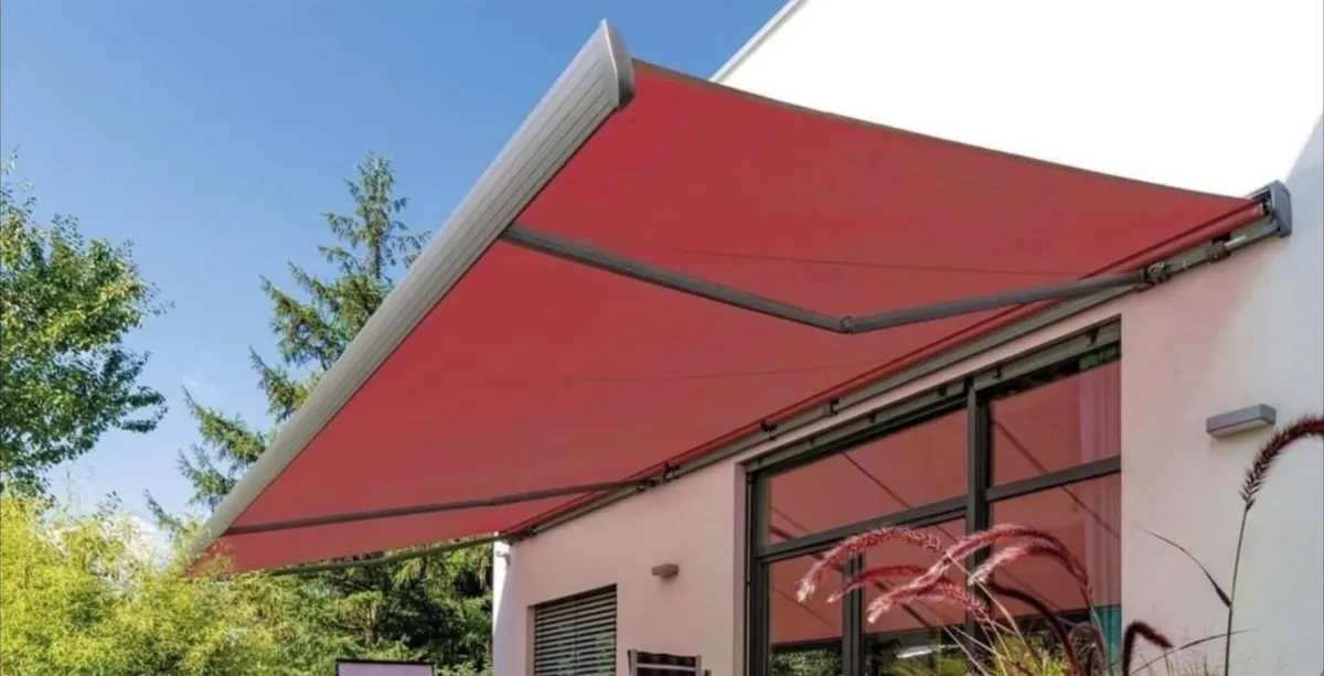 Rote Gelenkarmmarkise an einem Wohnhaus