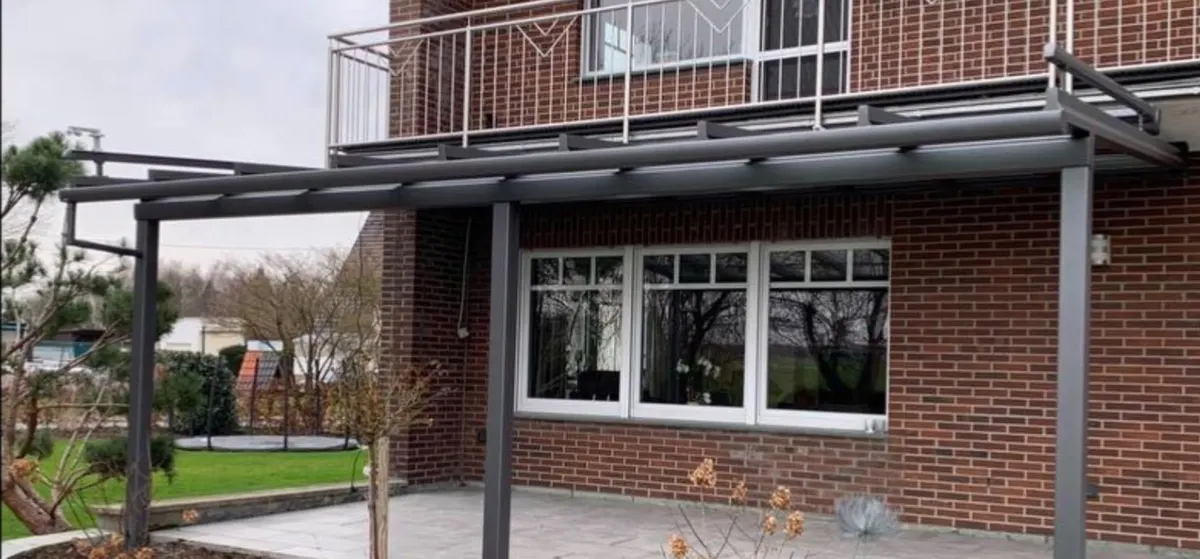 Terrassendach unter einem Balkon an Klinkerhaus
