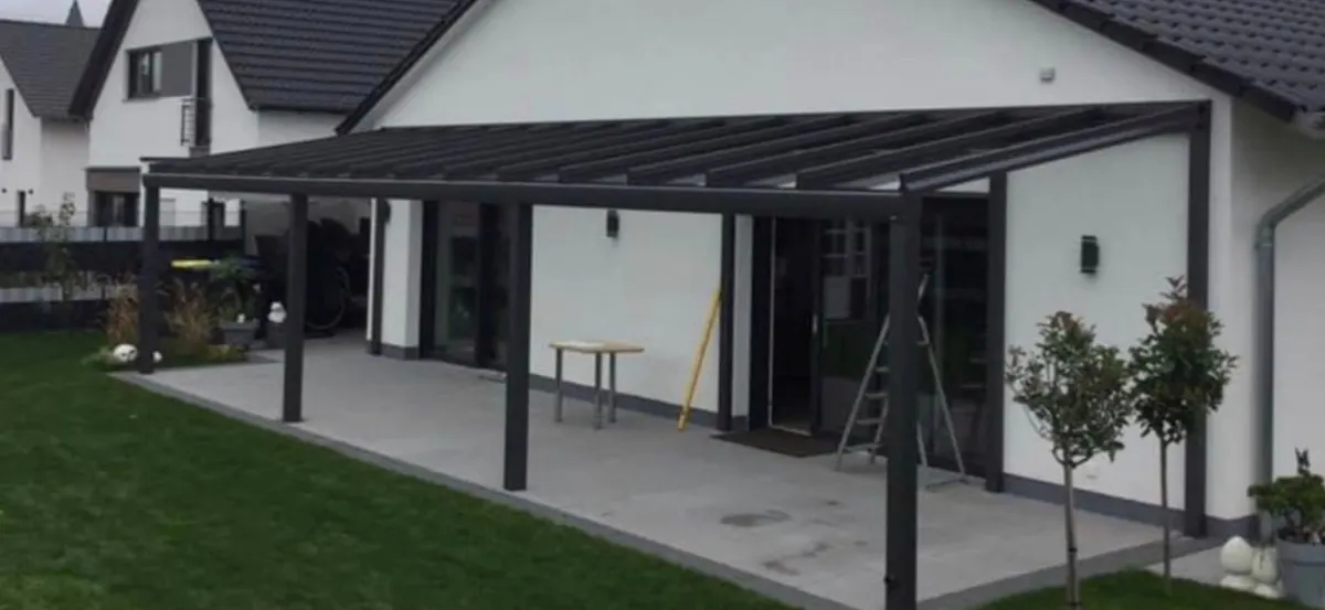 Breites Terrassendach entlang einer weißen Hausfassade