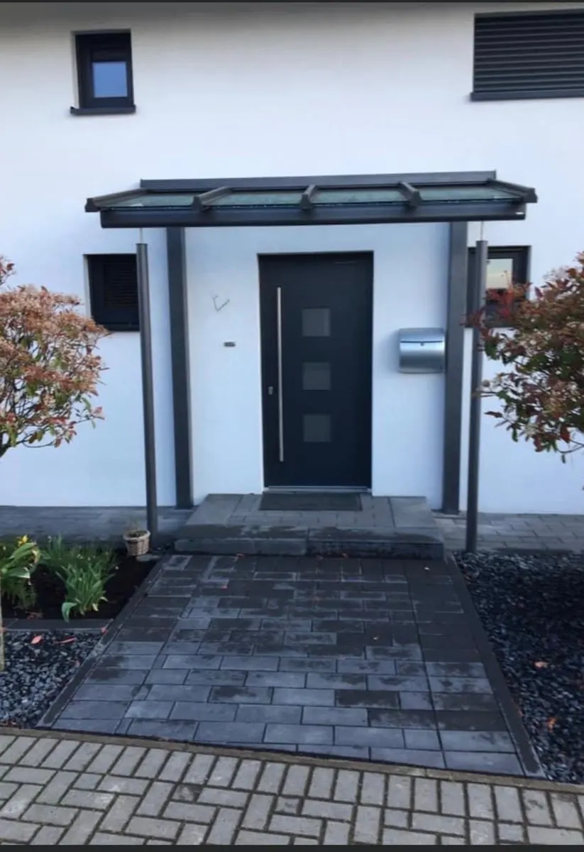 Vordach aus Aluminium und Glas über einer Haustür