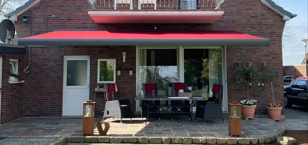Rote Markise an Klinkerhaus über Sitzplatz