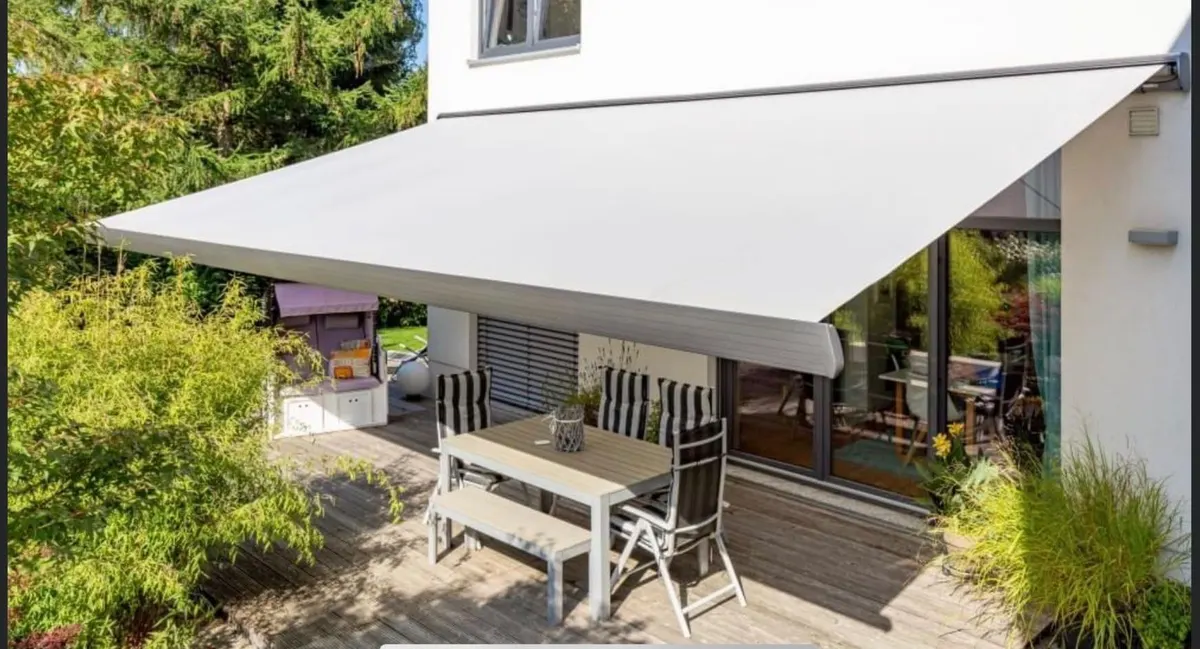 Helle Markise über einer Gartenterrasse